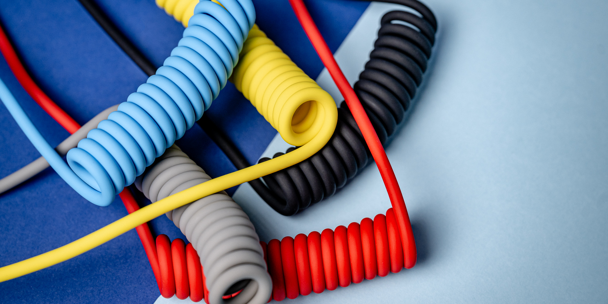 Kabel Newell USB-C - USB-C 100 W, 1,5 m, silikonowy, spiralny, niebiesko-pomarańczowy